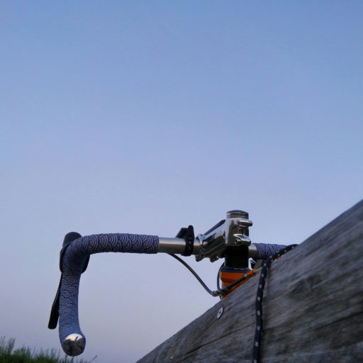 夕空と自転車のハンドルバー付近の写真