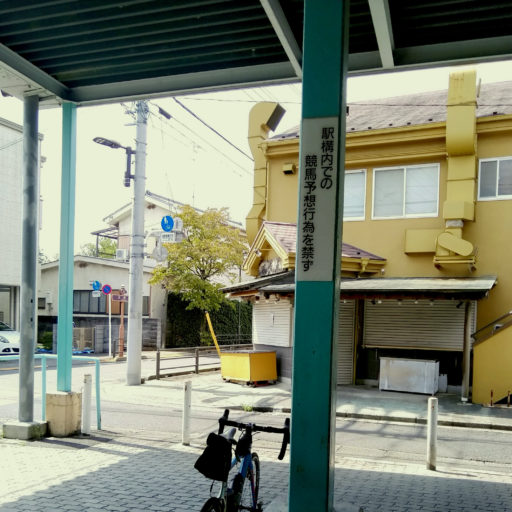 府中競馬場駅前の写真(「駅構内での競馬予想行為を禁ず」との掲示がある)