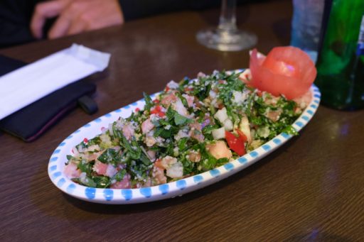 長皿に盛られたタッブーラサラダ。パセリとトマト、クスクスなどが混ぜ合わされている。