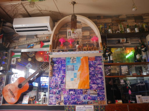 ビサン店内の壁面。お客さんと撮ったたくさんの記念写真が貼られている他、ガットギターやたくさんの雑貨が所狭しと並べられている。