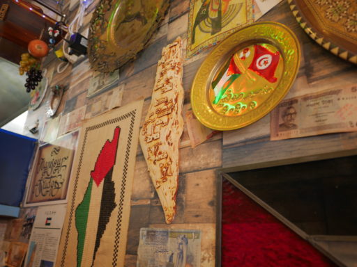ビサン店内の壁面。パレスチナの国土を象ったパレスチナ刺繍のタペストリーや陶器、現地のものと思しきお皿などが飾られている。