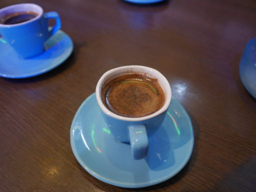 コーヒーの入った水色のカップと、揃いのソーサー。