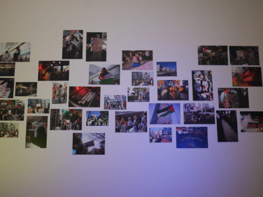 日本で行われたパレスチナ連帯デモの様子を写したたくさんの写真が壁面に貼られている様子。