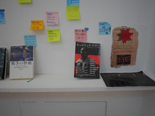 付箋と本が並んだ壁面。『戦争の枠組』『ケンドリック・ラマー』の本の上に、メッセージの書かれた付箋が貼られている。