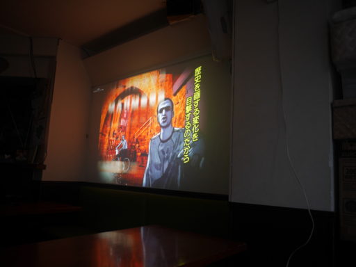 映画の一場面。「歴史を画する変化を目撃するのだから」という字幕。