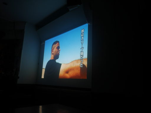 映画の一場面。「昔はオリーブ畑だった」という字幕。